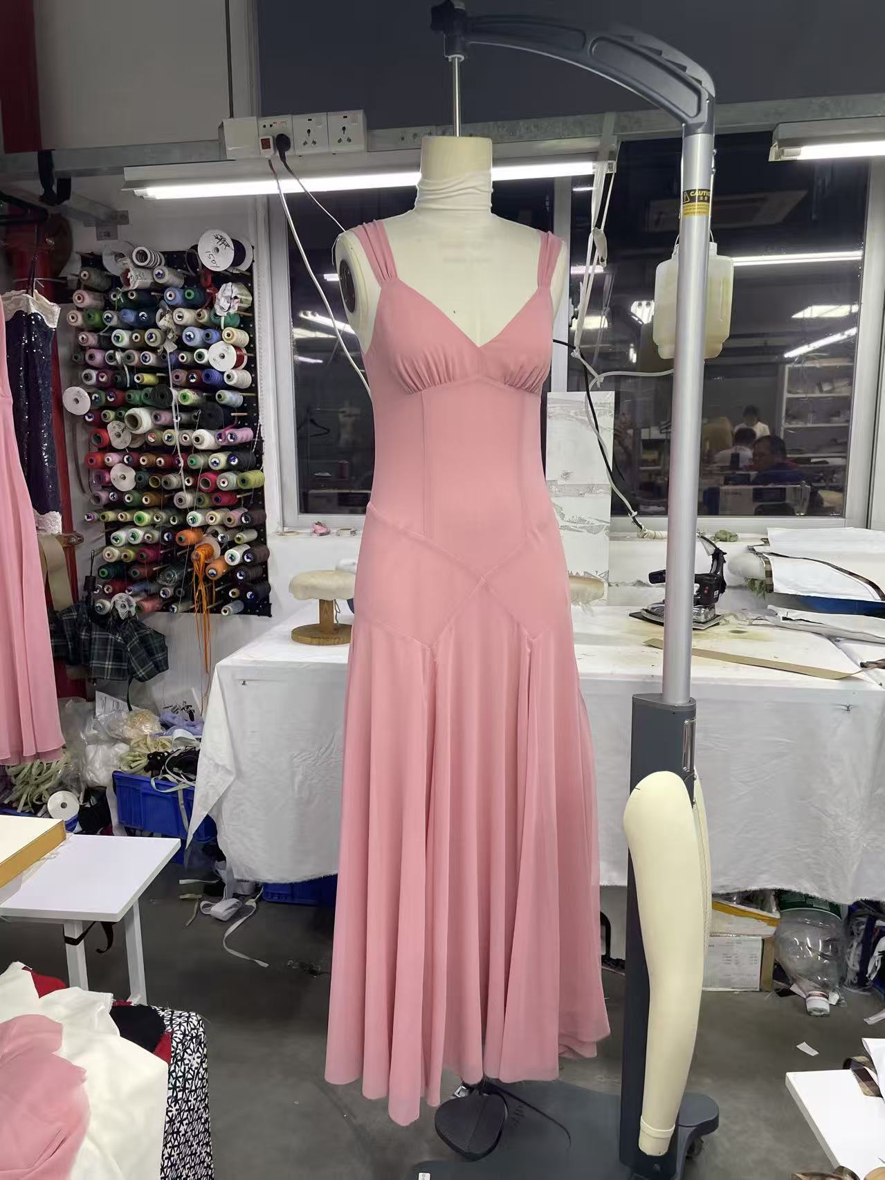Pink chiffon midi dress sample on dress form in pattern room