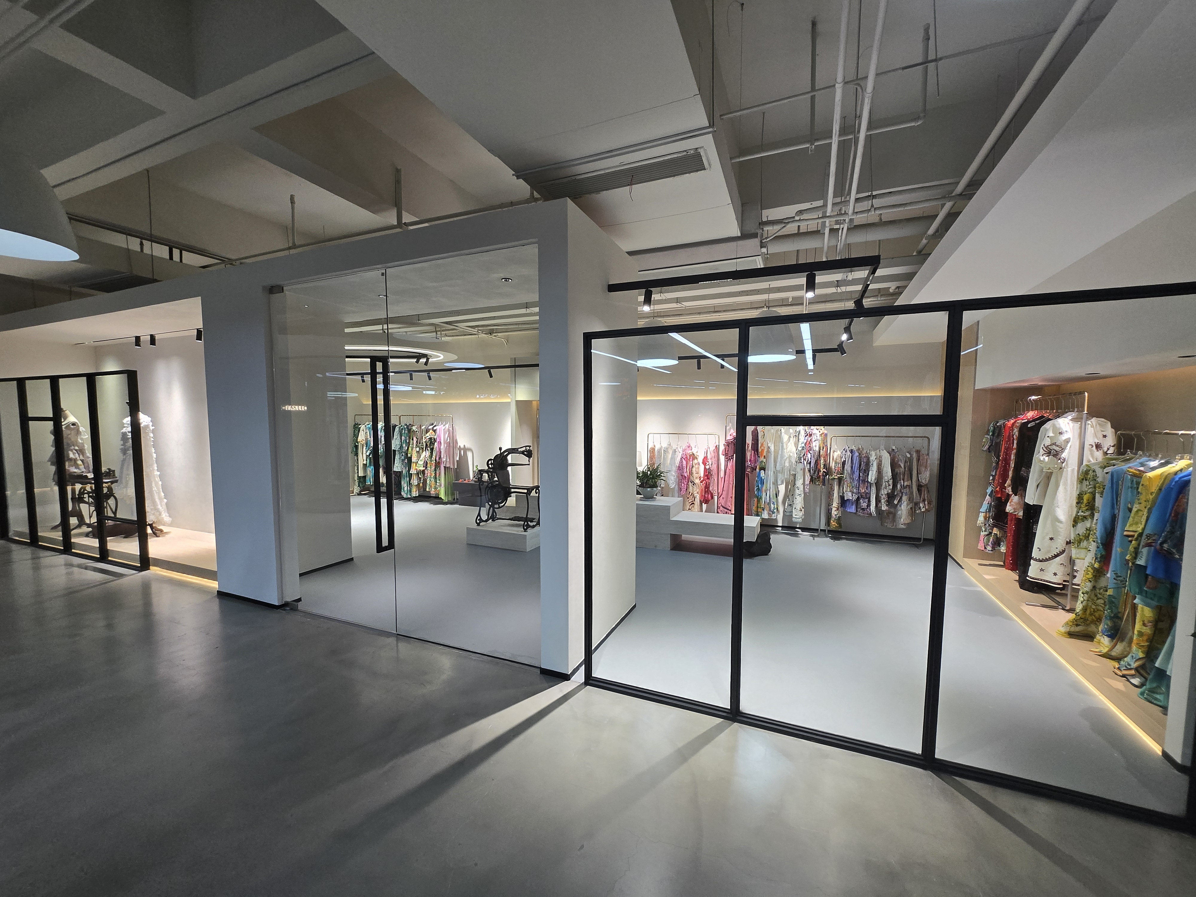 Modern showroom with glass-walled display areas for womenswear samples