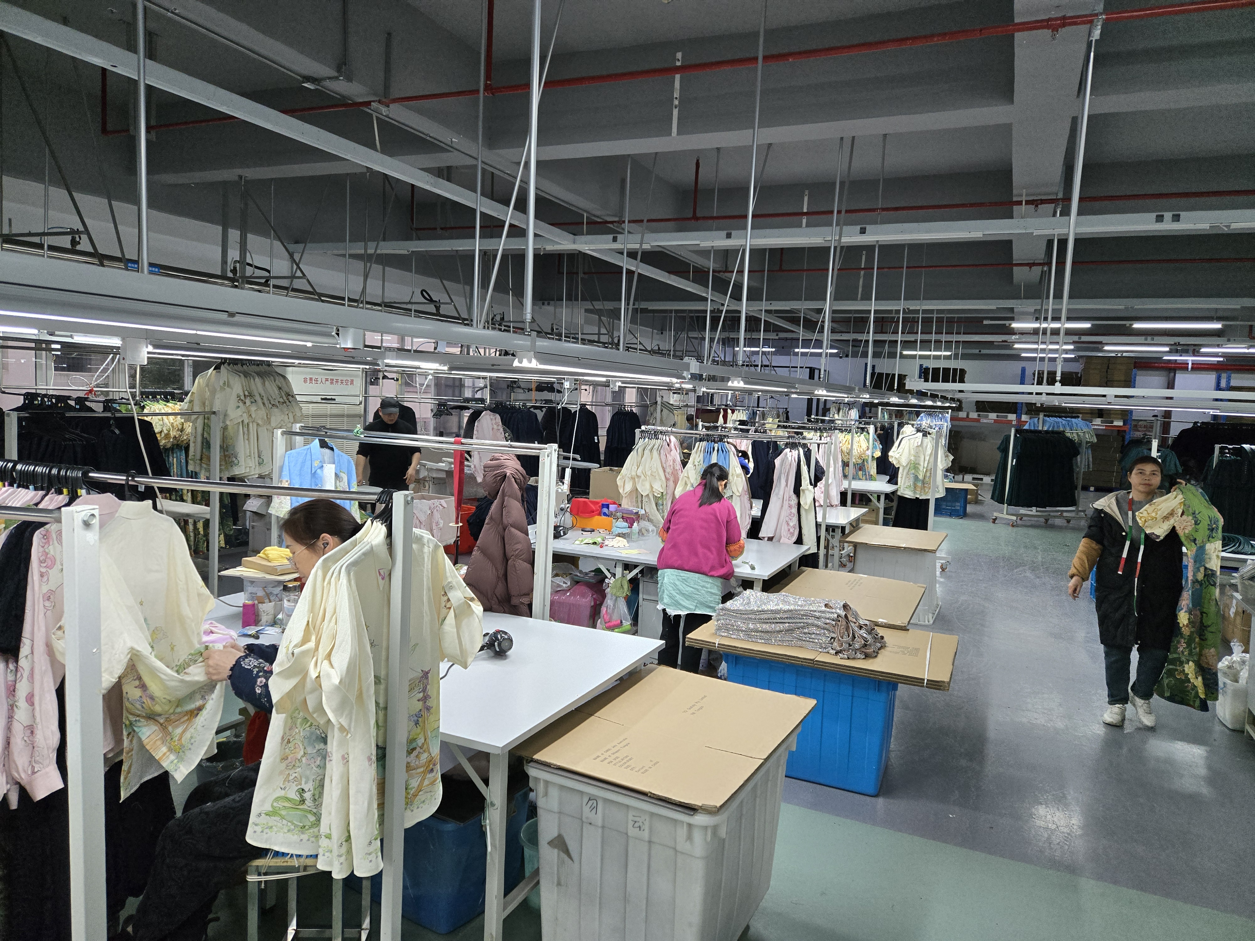 Garment inspection area — bulk run pieces laid out for quality checking before shipping